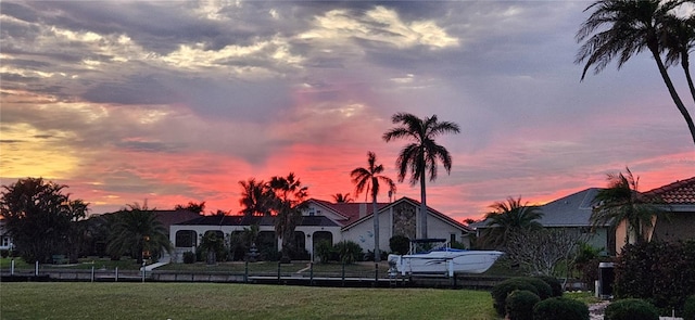 back house at dusk featuring a yard