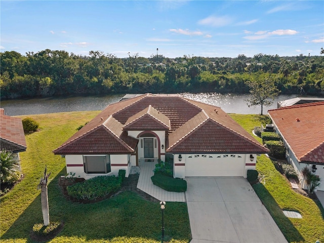 view of front facade featuring a front yard, a water view, and a garage