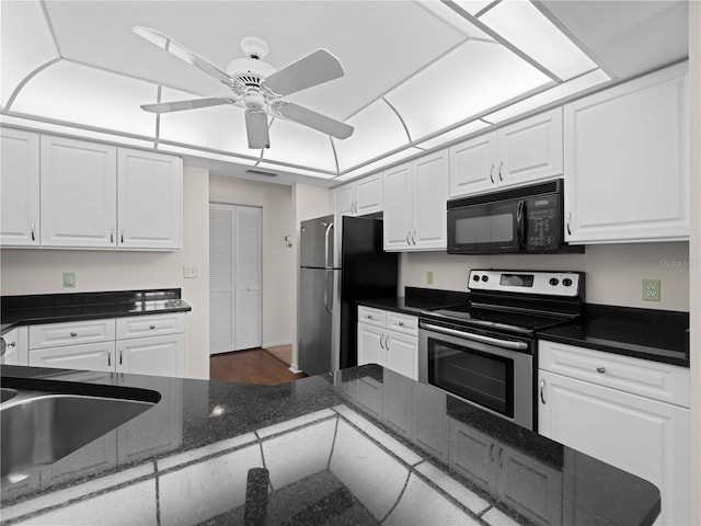 1946 Cove Pointe Dr, Venice, FL 34293 - kitchen with stainless steel appliances, white cabinets, ceiling fan, and dark stone countertops