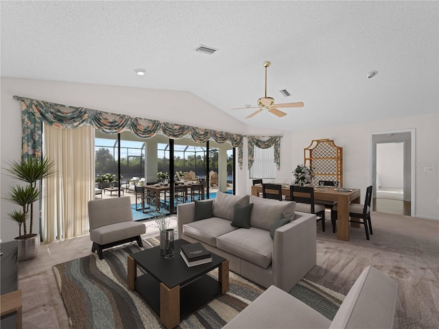 living room with a textured ceiling, carpet floors, ceiling fan, and lofted ceiling