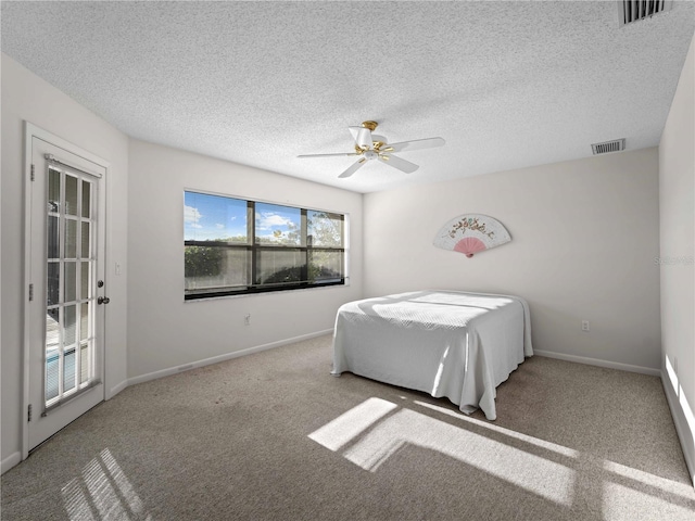 carpeted bedroom with ceiling fan and a textured ceiling