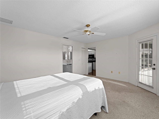 carpeted bedroom featuring a textured ceiling, connected bathroom, access to outside, and ceiling fan