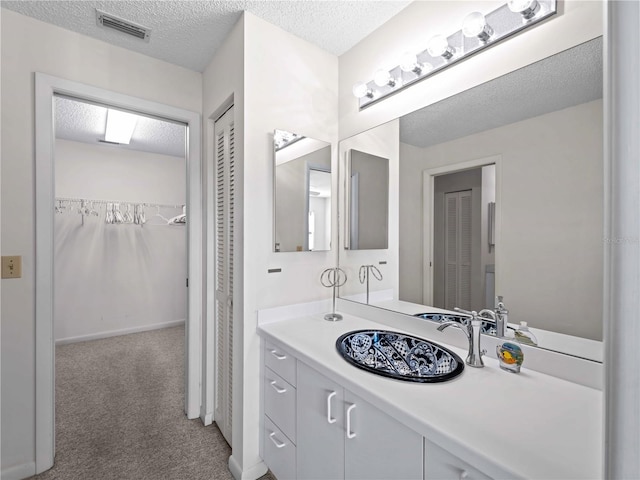 bathroom featuring a textured ceiling and vanity