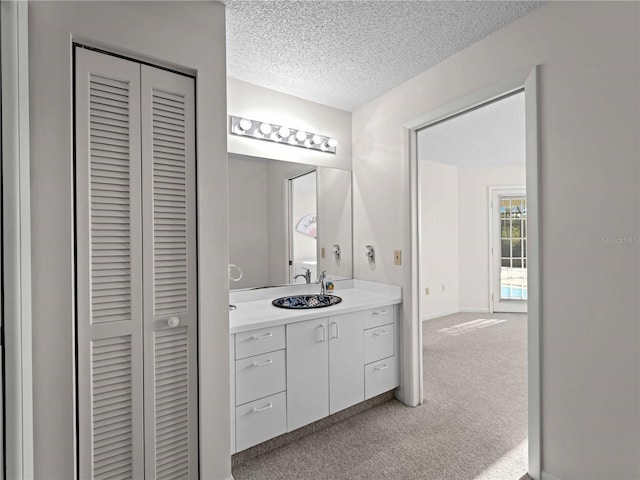 1946 Cove Pointe Dr, Venice, FL 34293 - bathroom featuring a closet, vanity, and a textured ceiling