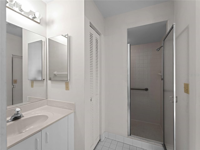 bathroom with a tile shower, tile patterned floors, and vanity