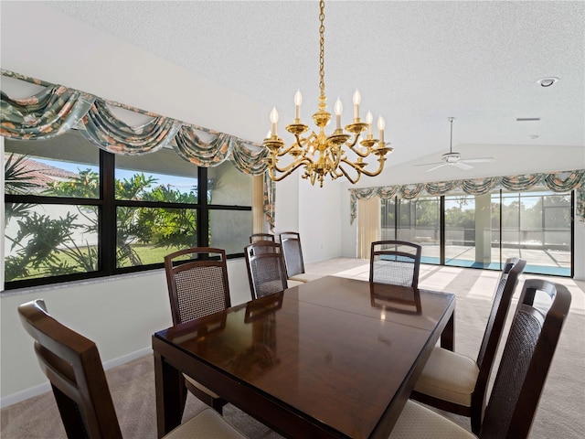 dining area featuring ceiling fan with notable chandelier, a healthy amount of sunlight, light colored carpet, and vaulted ceiling