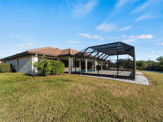 back of house with a lawn, glass enclosure, and a swimming pool