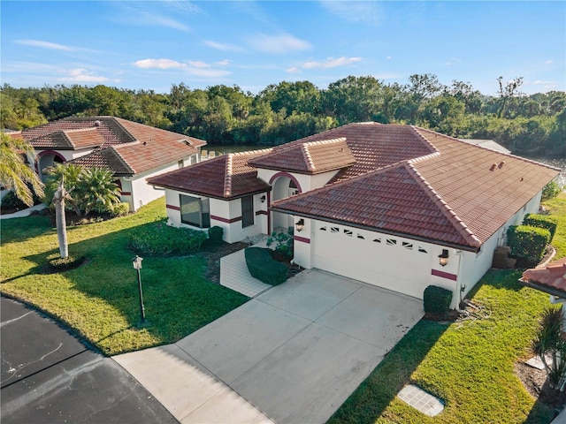 1946 Cove Pointe Dr, Venice, FL 34293 - view of front of home featuring an attached garage, a tiled roof, a front yard, driveway, and stucco siding