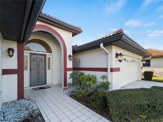 1946 Cove Pointe Dr, Venice, FL 34293 - doorway to property with stucco siding, a garage, a tiled roof, and driveway