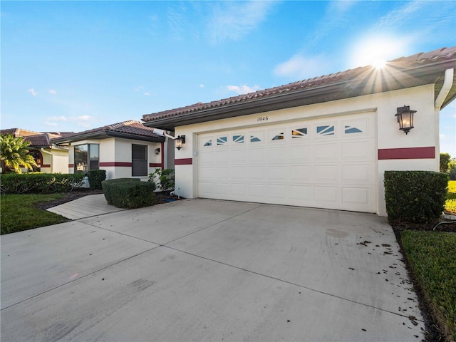 1946 Cove Pointe Dr, Venice, FL 34293 - view of front facade featuring driveway, stucco siding, a tile roof, and a garage