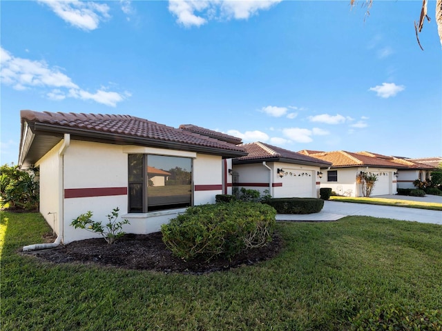 1946 Cove Pointe Dr, Venice, FL 34293 - view of front of property featuring an attached garage, a front lawn, a tiled roof, concrete driveway, and stucco siding