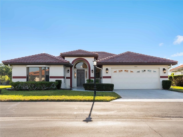 1946 Cove Pointe Dr, Venice, FL 34293 - mediterranean / spanish house with a garage, stucco siding, driveway, and a tile roof