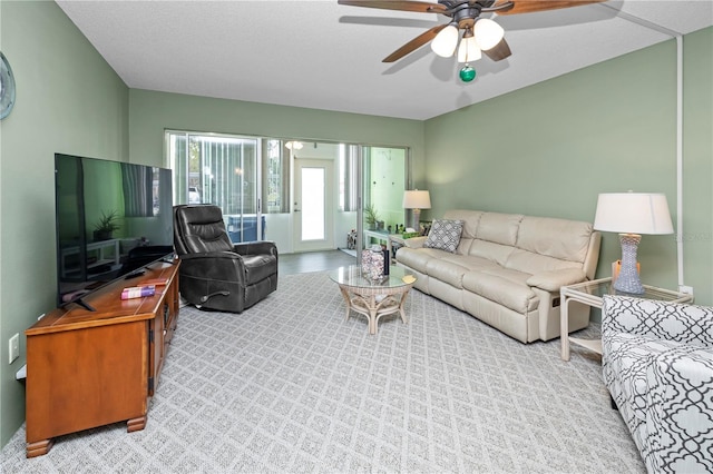 living room with light carpet, a textured ceiling, and ceiling fan