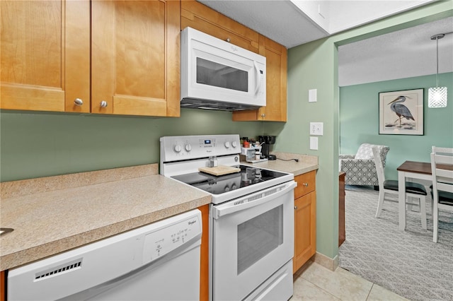 kitchen with light tile patterned floors, white appliances, and a textured ceiling