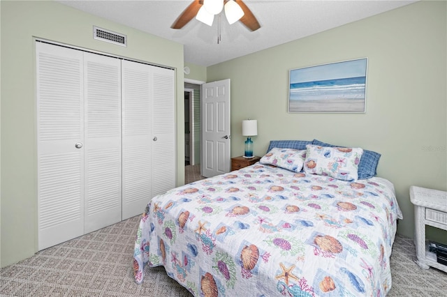 carpeted bedroom featuring a textured ceiling, a closet, and ceiling fan