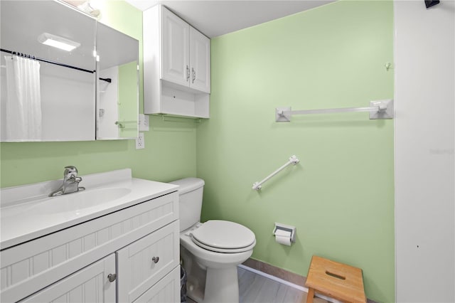 bathroom featuring wood-type flooring, vanity, toilet, and curtained shower