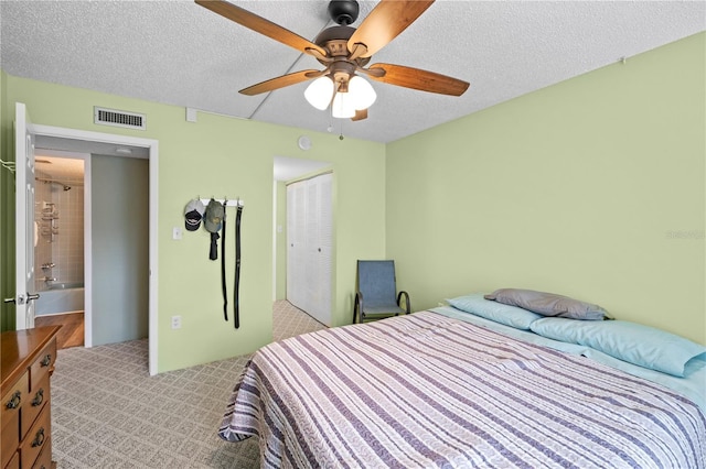 carpeted bedroom with a textured ceiling, a closet, and ceiling fan