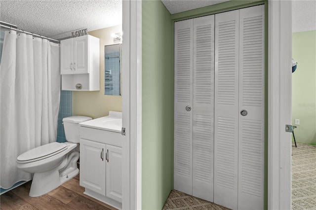 bathroom featuring vanity, hardwood / wood-style floors, a textured ceiling, and toilet