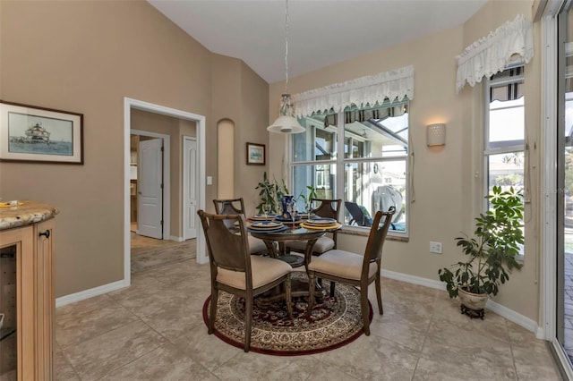 tiled dining room featuring lofted ceiling