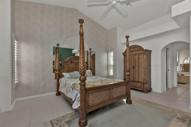 bedroom featuring tile patterned floors, ceiling fan, lofted ceiling, and ensuite bath