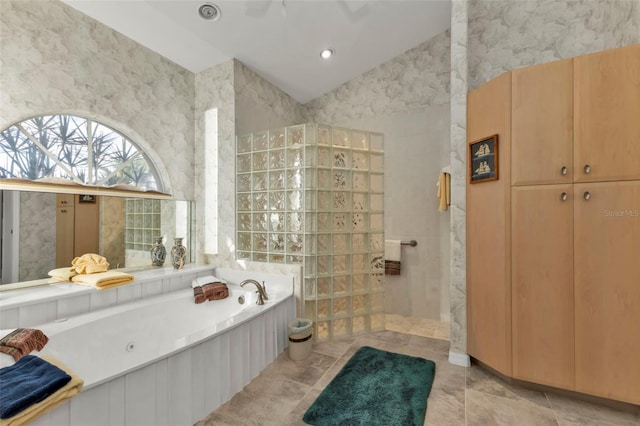 bathroom featuring shower with separate bathtub, tile walls, and lofted ceiling