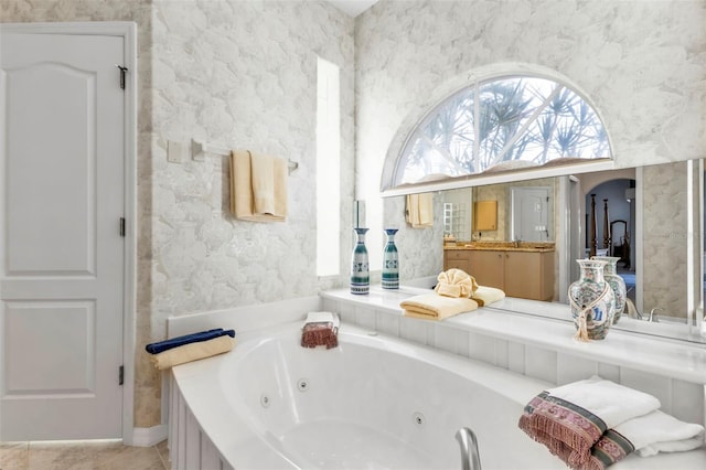 bathroom with vanity and tiled tub