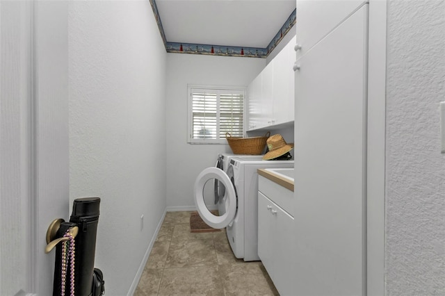 laundry room featuring cabinets, washing machine and dryer, and light tile patterned flooring