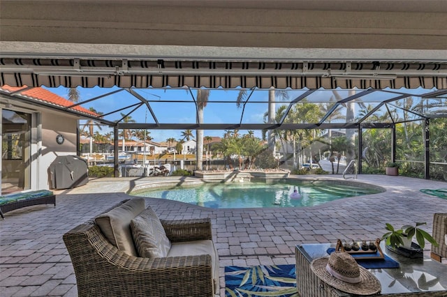 view of pool with a grill, a patio area, and a lanai