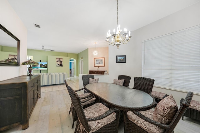 dining space featuring a notable chandelier and light wood-type flooring