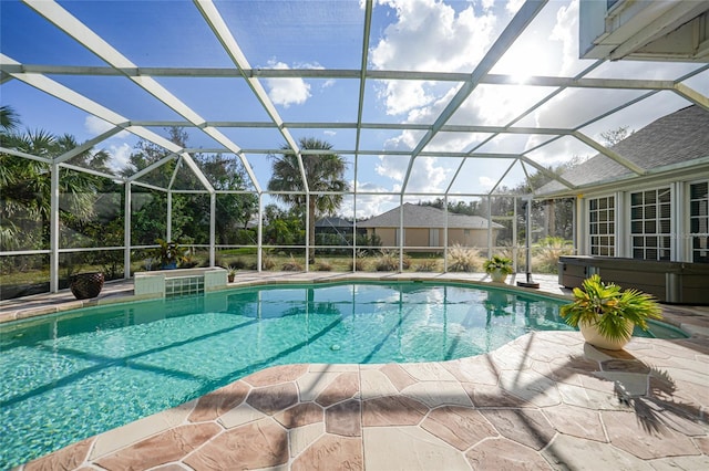 view of swimming pool featuring glass enclosure and a patio area