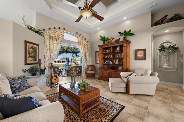 living room with a towering ceiling, ceiling fan, and crown molding