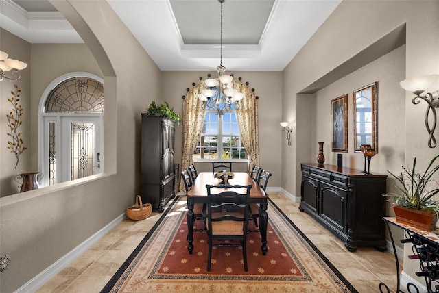 dining area with an inviting chandelier and a raised ceiling