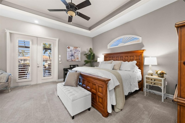 carpeted bedroom featuring access to outside, a raised ceiling, ceiling fan, and french doors