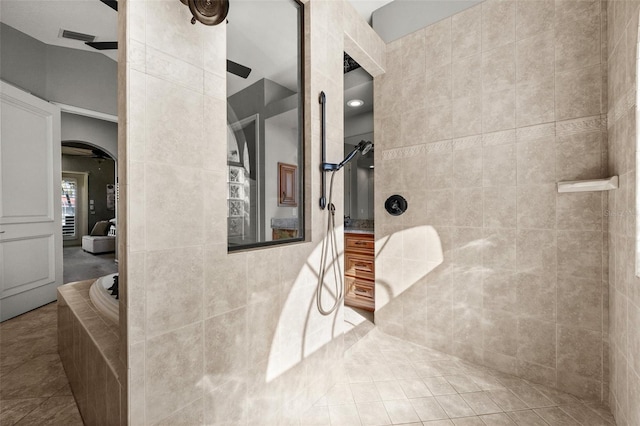 bathroom with tile patterned floors, ceiling fan, separate shower and tub, and tile walls