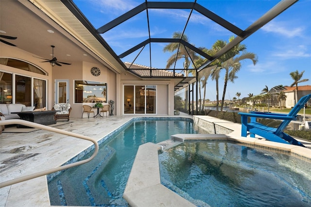 view of pool featuring exterior bar, glass enclosure, ceiling fan, and a patio area