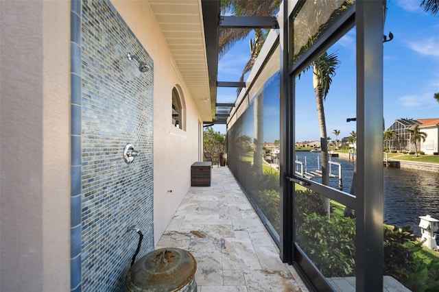 sunroom featuring a water view