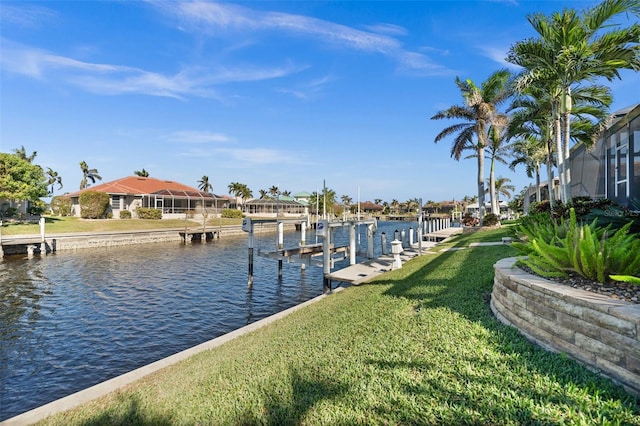 view of dock with a lawn and a water view