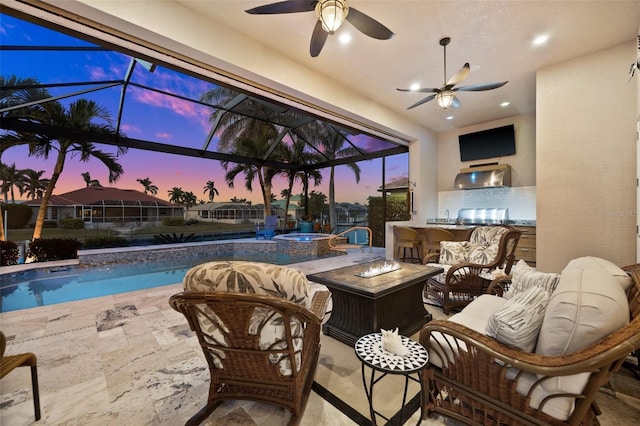 view of swimming pool featuring a lanai, ceiling fan, exterior kitchen, a bar, and a patio