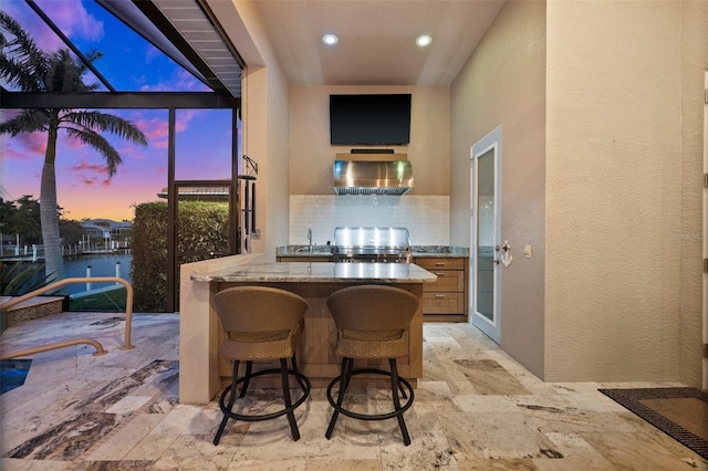 view of patio / terrace with glass enclosure, a grill, and a wet bar