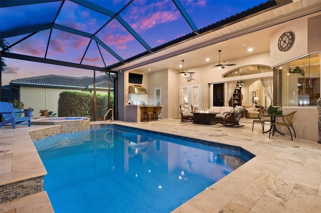 pool at dusk with an outdoor living space, exterior bar, ceiling fan, an in ground hot tub, and a patio