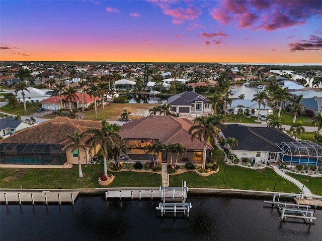 aerial view at dusk featuring a water view