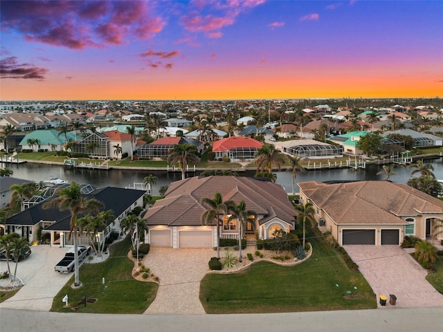 aerial view at dusk featuring a water view