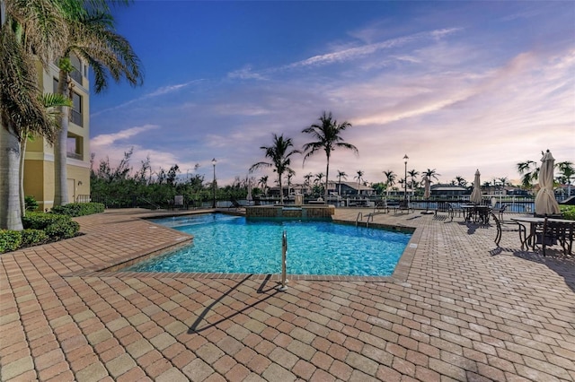 pool at dusk with a patio