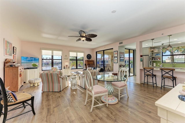 dining room with ceiling fan and light hardwood / wood-style flooring