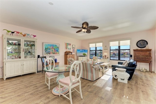 dining space with ceiling fan and light hardwood / wood-style flooring