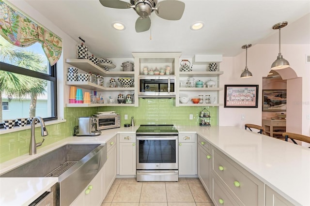 kitchen with decorative light fixtures, white cabinetry, backsplash, and appliances with stainless steel finishes