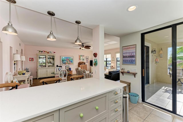 kitchen with gray cabinetry, ceiling fan, light tile patterned floors, and hanging light fixtures