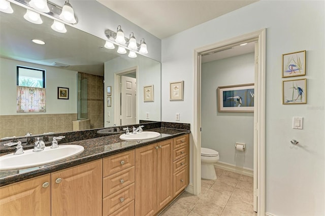 bathroom featuring tile patterned flooring, vanity, and toilet