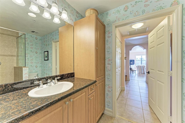 bathroom with tile patterned floors, vanity, toilet, and walk in shower