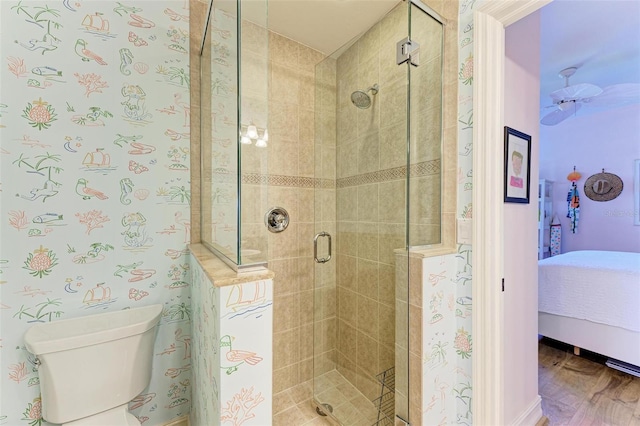 bathroom with hardwood / wood-style flooring, toilet, and an enclosed shower